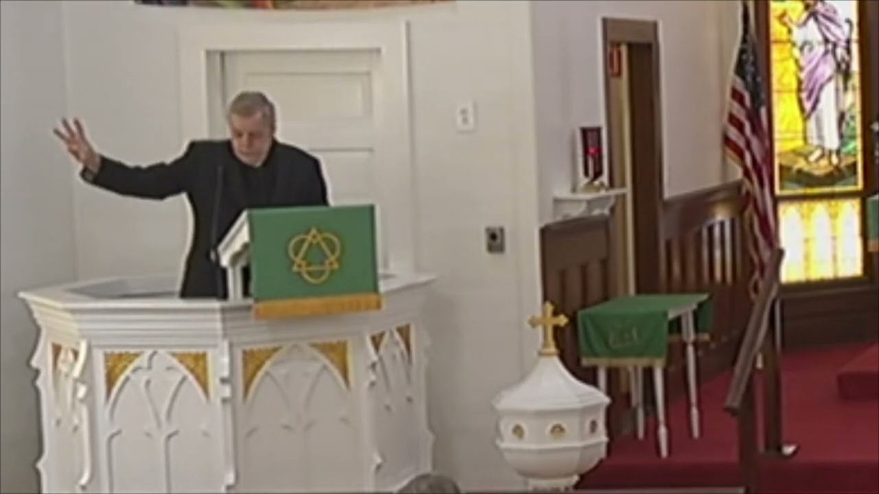 Pastor Jan Putnam preaching from the historic pulpit at St. John Lutheran Church